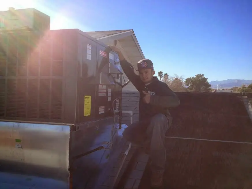 HVAC technician performing Boiler Repair on a rooftop unit in Rexburg